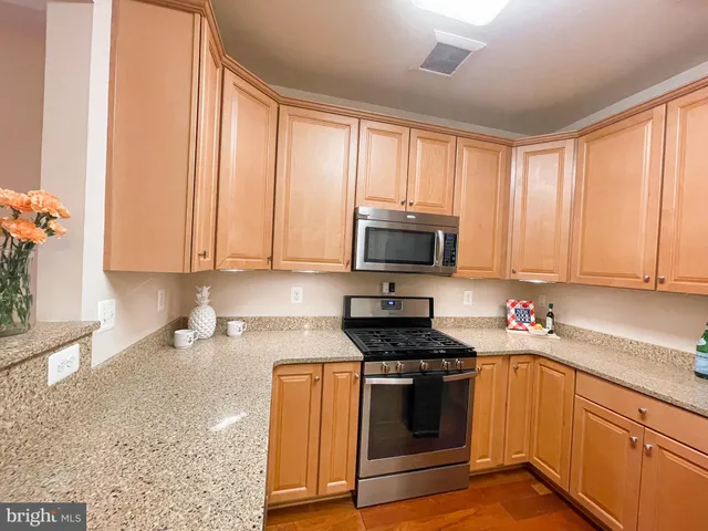 a kitchen with stainless steel appliances white cabinets and a stove top oven