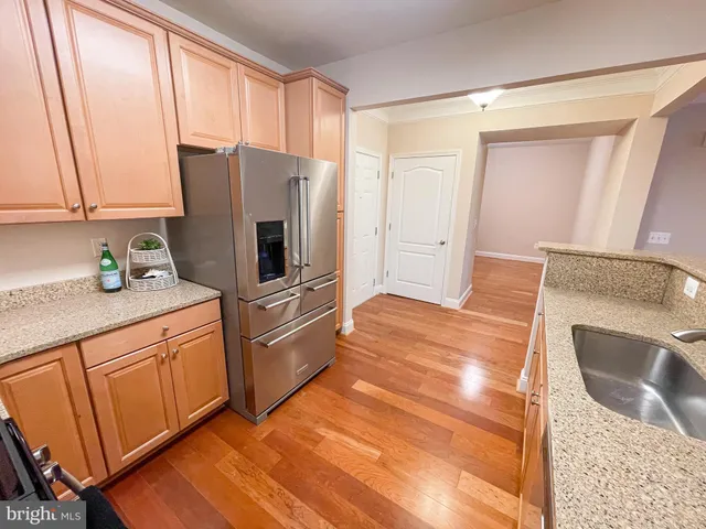 a kitchen with stainless steel appliances granite countertop a refrigerator a stove a sink and a microwave