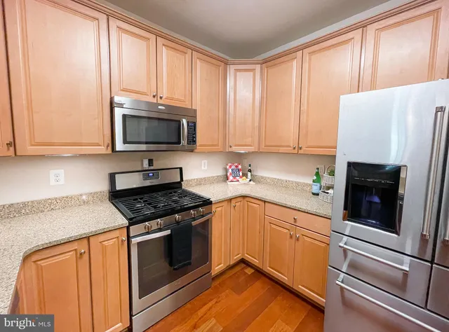 a kitchen with granite countertop a stove top oven microwave and cabinets