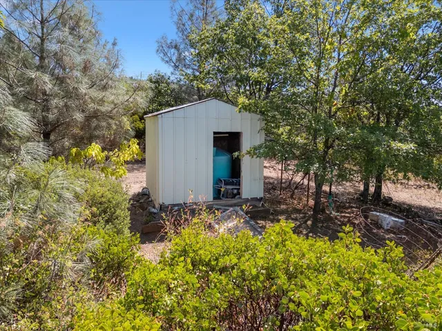 a backyard of a house with trees and flowers
