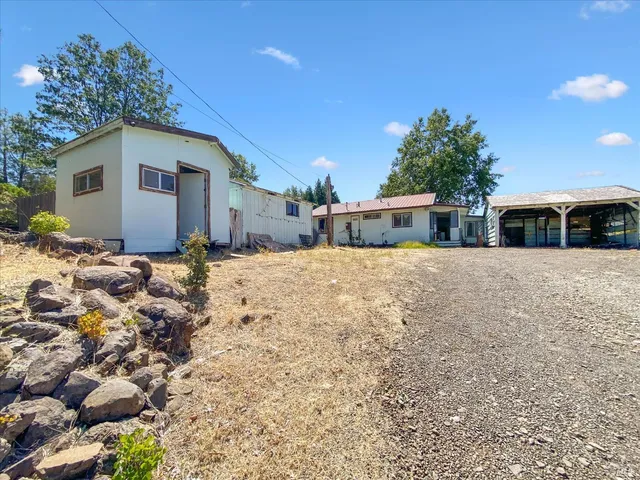 a view of a house with a yard and sitting area