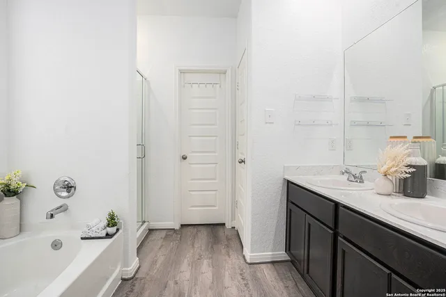 a bathroom with a sink a tub and a mirror
