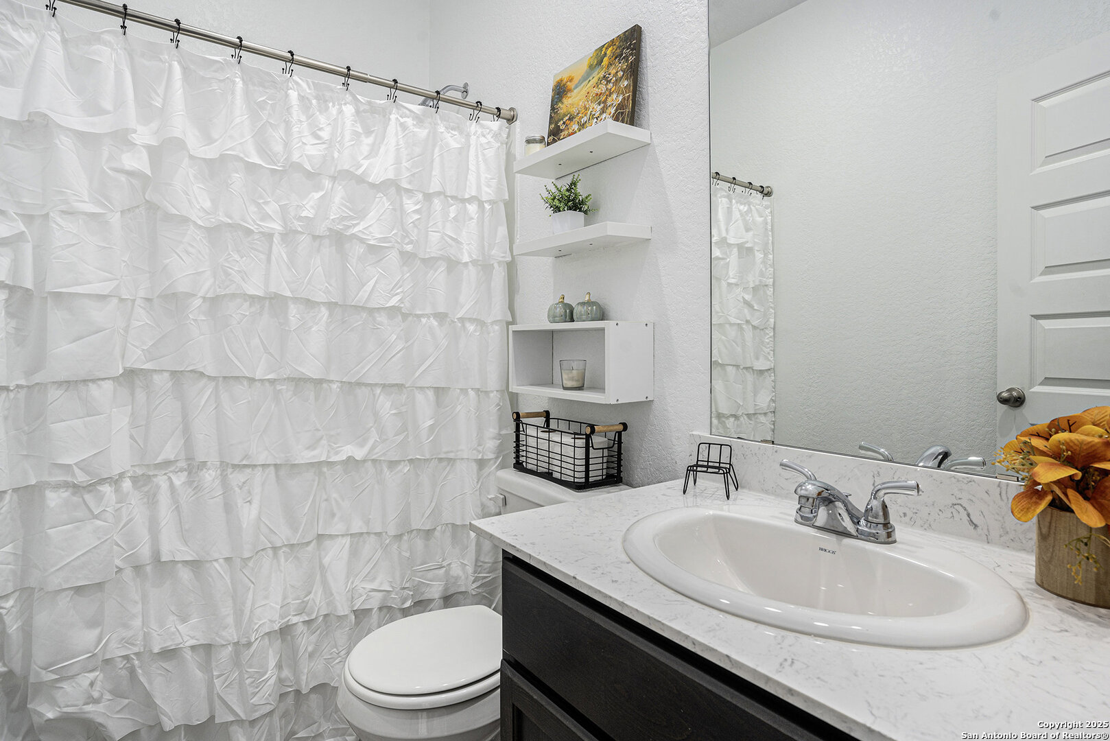 16615 Ginger Crossing Elmendorf, TX 78112 - Photo 19 of 31 a bathroom with a sink a toilet and shower curtain
