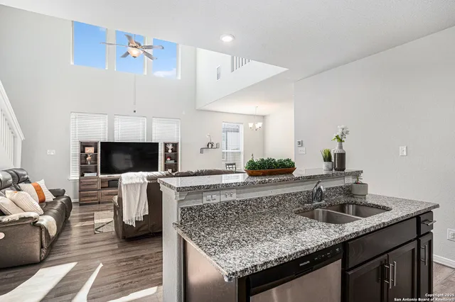 a kitchen with a sink and a stove top oven with wooden floor