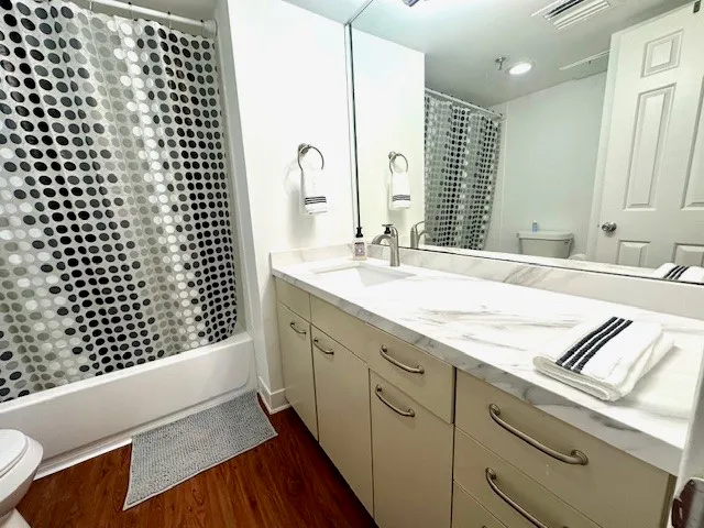a bathroom with a granite countertop sink a large mirror and a shower
