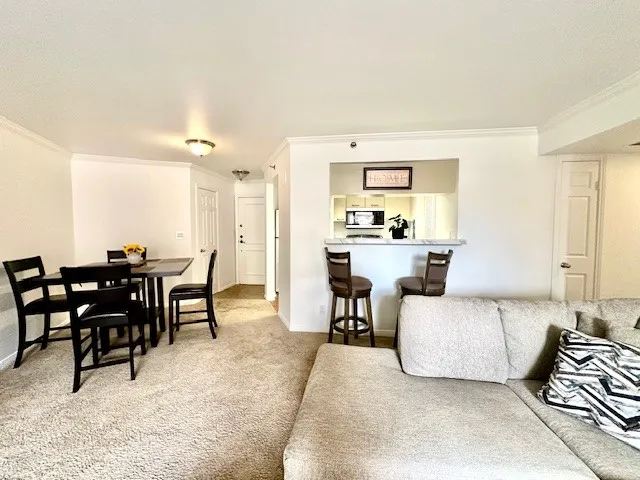 a living room with furniture and a dining table