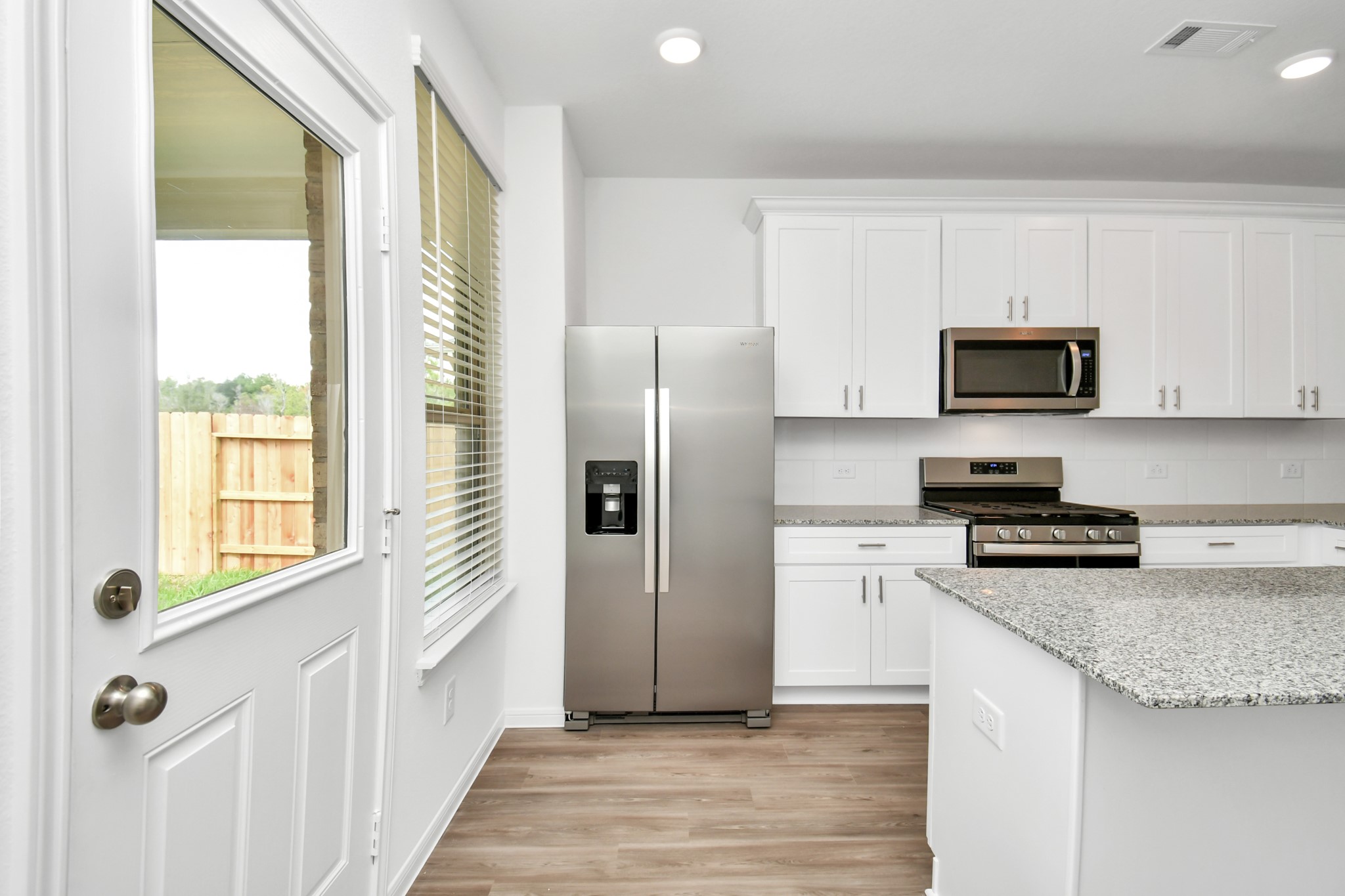 16150 Elbridge Court Conroe, TX 77302 - Photo 25 of 46 The kitchen blends indoor and outdoor living, with access to the back patio in a perfect blend of functionality, style, and the beauty of nature, creating a welcoming and versatile space.