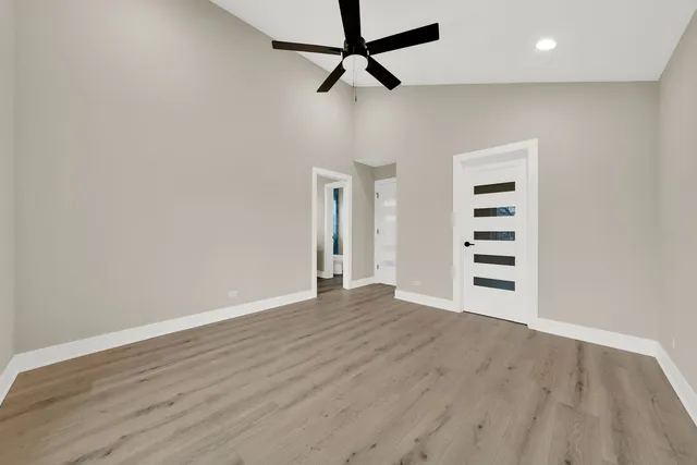 a view of a big room with wooden floor and windows
