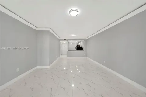 a view of a big room with wooden floor and windows