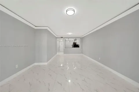 a view of a big room with wooden floor and windows
