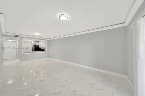 a view of a big room with wooden floor and windows