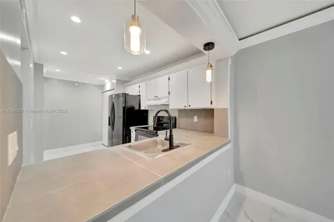 a kitchen with kitchen island a sink stainless steel appliances and cabinets