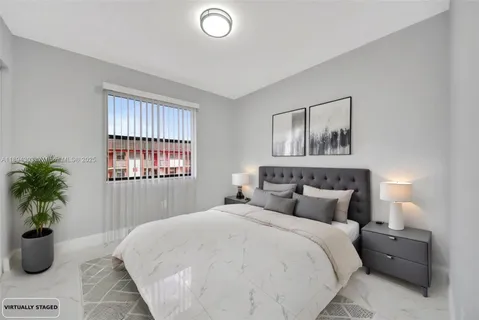 a bedroom with a large bed and a potted plant