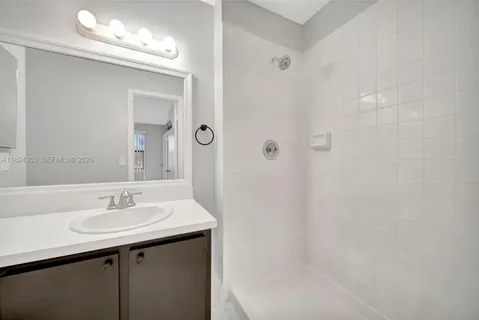 a bathroom with a sink a shower and a mirror
