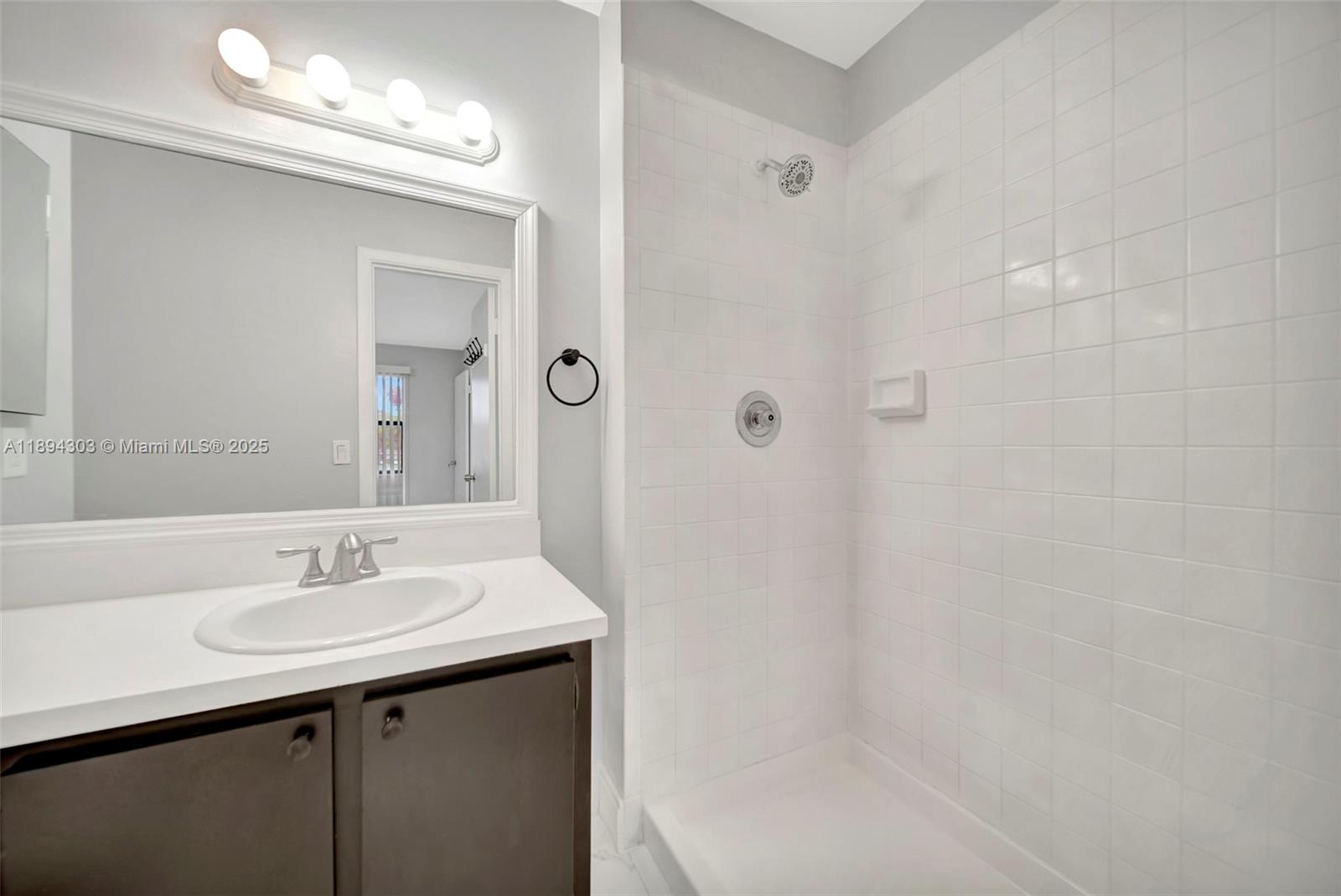 871 Northeast 207th Terrace, Unit 4202 Miami, FL 33179 - Photo 9 of 27 a bathroom with a sink a shower and a mirror