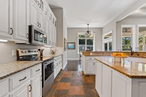a spacious en suite bathroom with a granite countertop sink mirror and shower