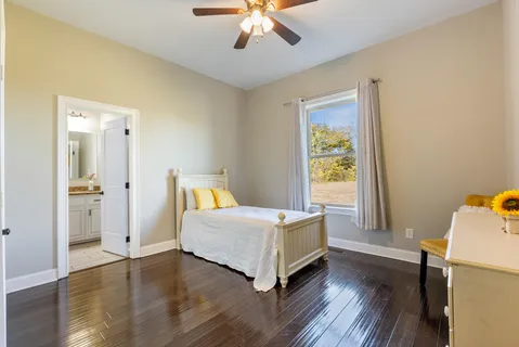 a living room with furniture kitchen view and a wooden floor