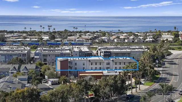 an aerial view of a building with outdoor space swimming pool and ocean view
