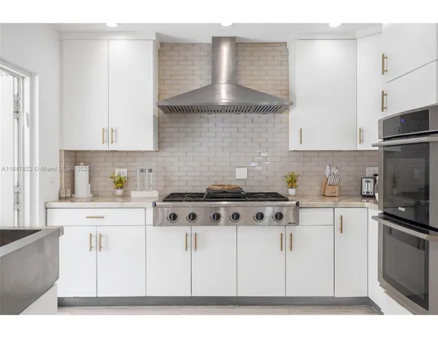 a kitchen with stainless steel appliances a stove a sink and a refrigerator