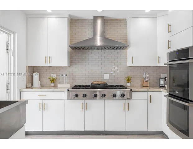 a kitchen with stainless steel appliances a stove a sink and a refrigerator