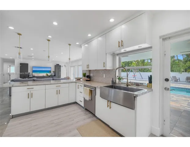 a kitchen with stainless steel appliances granite countertop a stove a sink and a refrigerator