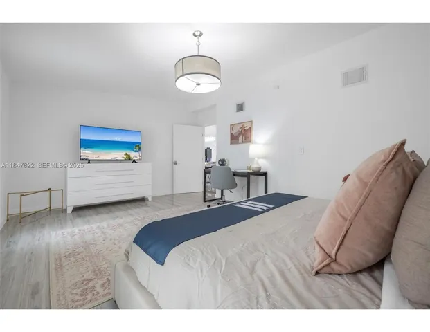 a bedroom with a bed mirror and a window