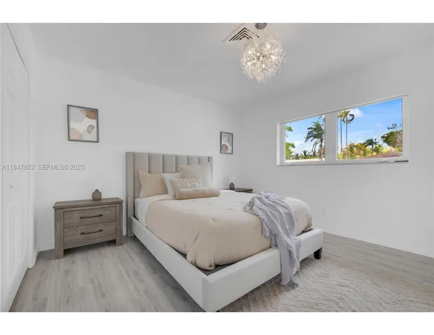 a bedroom with a bed and a chandelier