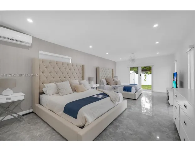 a spacious bedroom with a bed a couch and a potted plant