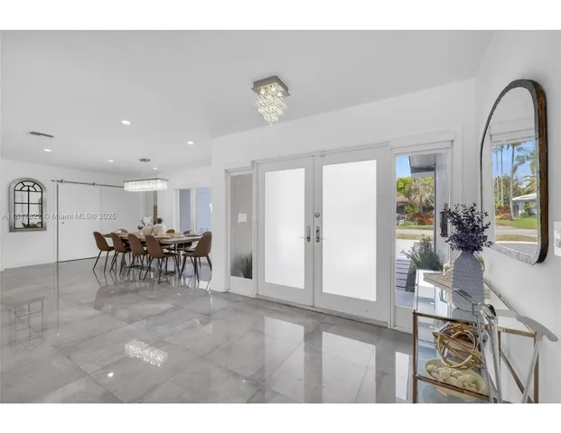 a view of a dining room with furniture and a chandelier