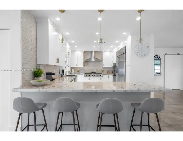 a kitchen with a dining table chairs sink and cabinets