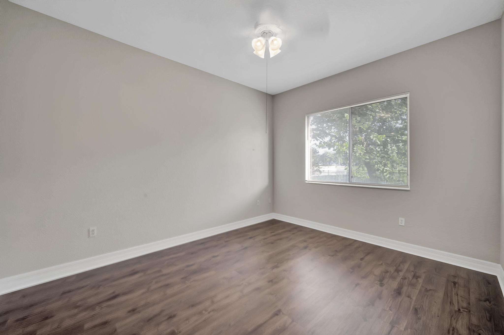 55 Southeast Palermo, Unit 106 Stuart, FL 34994 - Photo 11 of 39 wooden floor in an empty room with a window