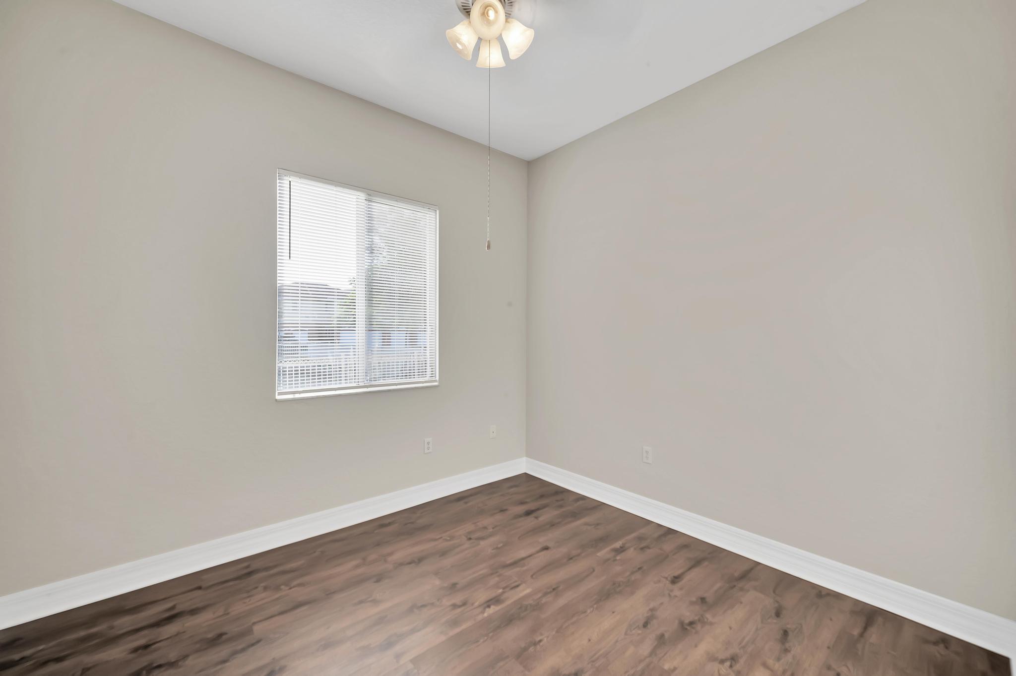 55 Southeast Palermo, Unit 106 Stuart, FL 34994 - Photo 13 of 39 an empty room with wooden floor and a window