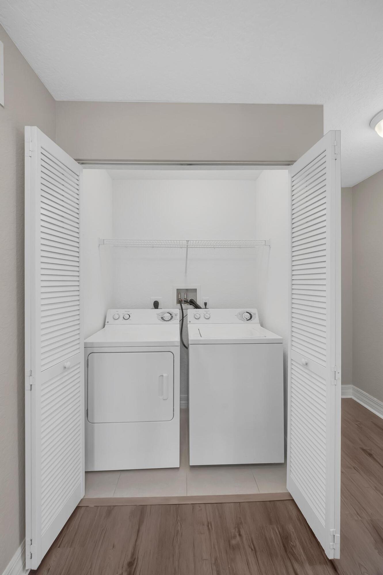 55 Southeast Palermo, Unit 106 Stuart, FL 34994 - Photo 17 of 39 a utility room with cabinets washer and dryer