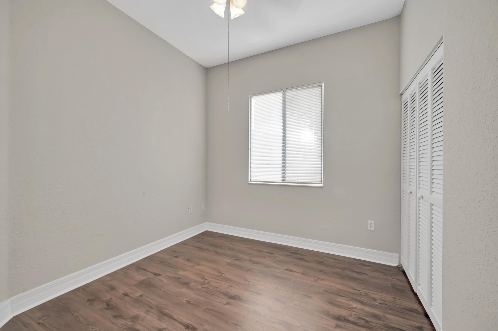 55 Southeast Palermo, Unit 106 Stuart, FL 34994 - Photo 19 of 39 an empty room with wooden floor and windows