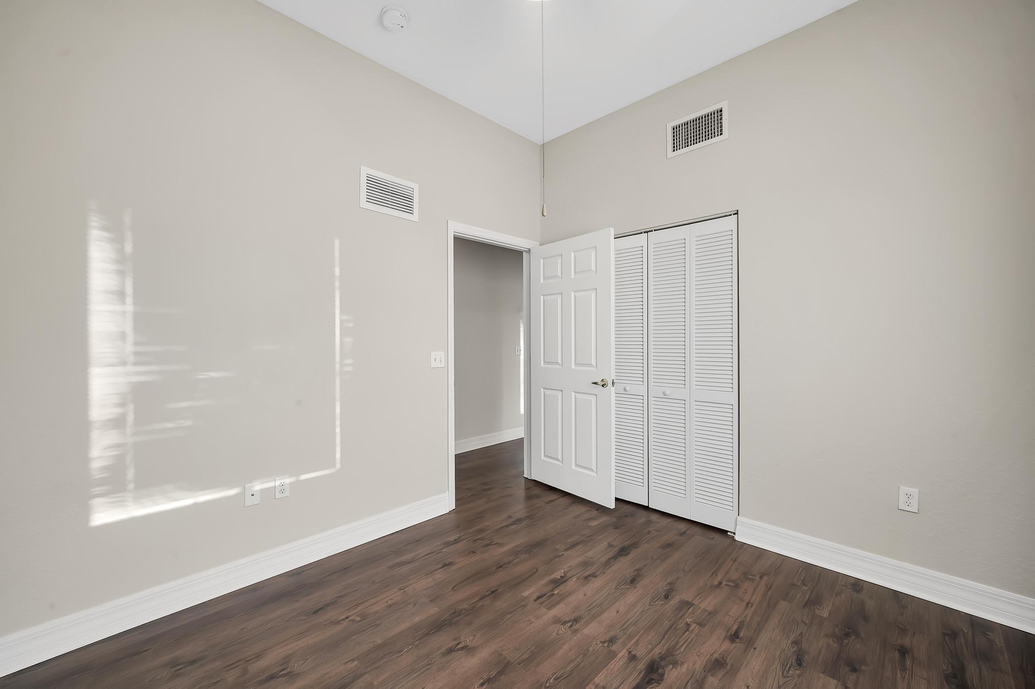 55 Southeast Palermo, Unit 106 Stuart, FL 34994 - Photo 23 of 39 a view of an empty room with wooden floor and a window