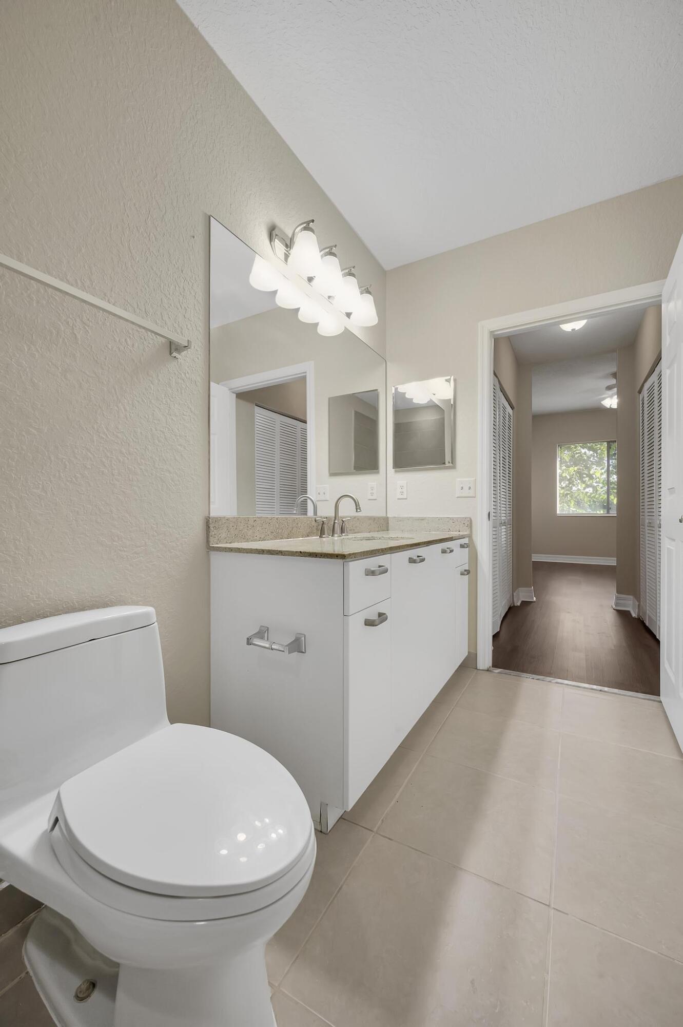 55 Southeast Palermo, Unit 106 Stuart, FL 34994 - Photo 24 of 39 a bathroom with a toilet sink and mirror
