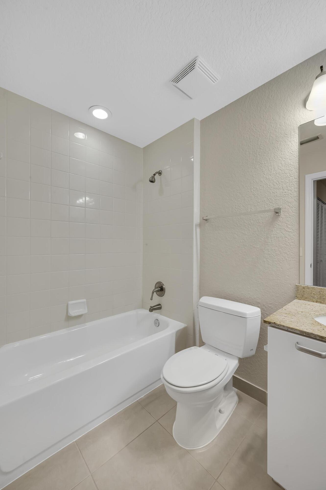 55 Southeast Palermo, Unit 106 Stuart, FL 34994 - Photo 25 of 39 a white toilet sitting next to a bath tub