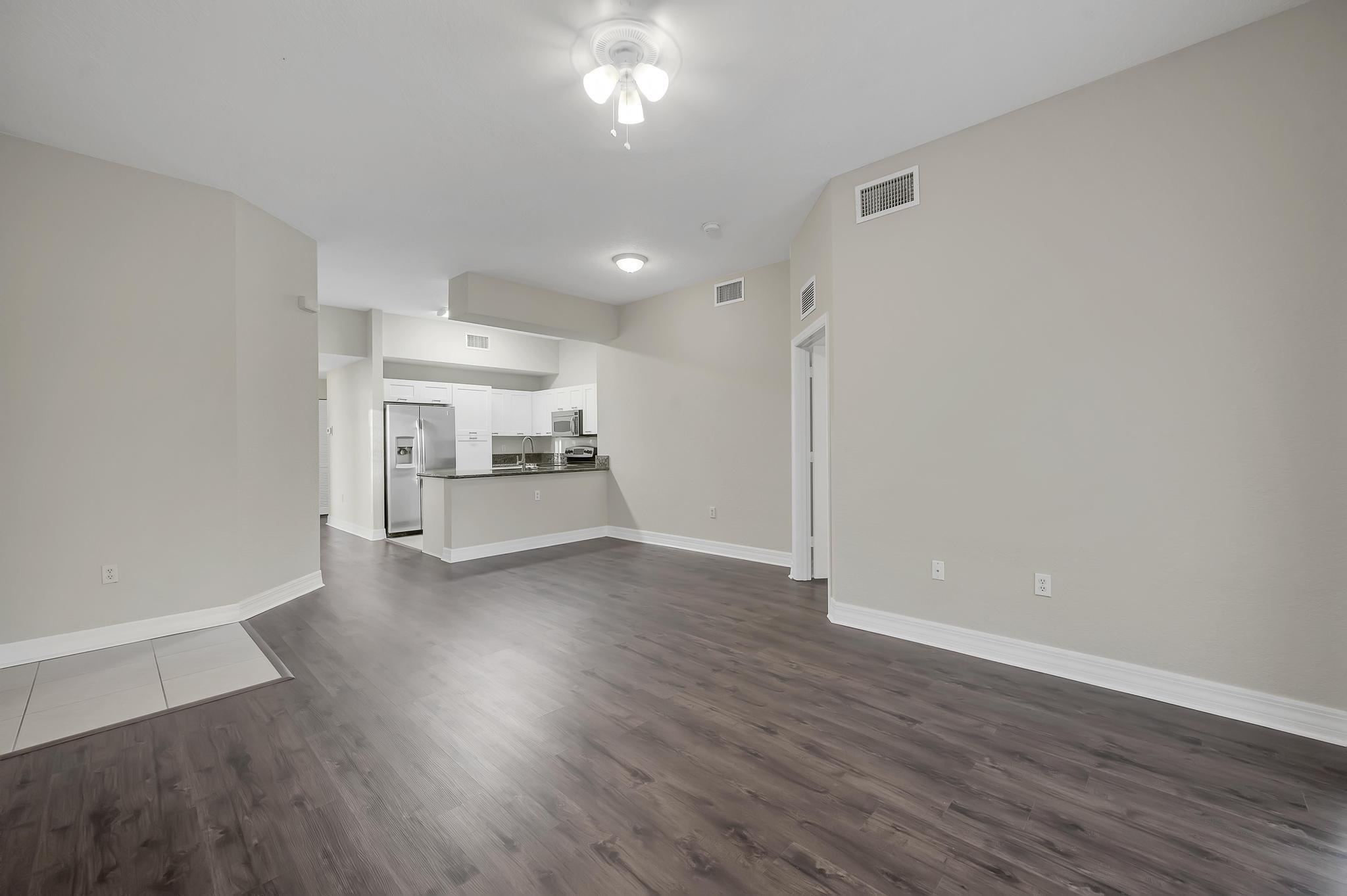 55 Southeast Palermo, Unit 106 Stuart, FL 34994 - Photo 4 of 39 a view of a room with wooden floor and kitchen view