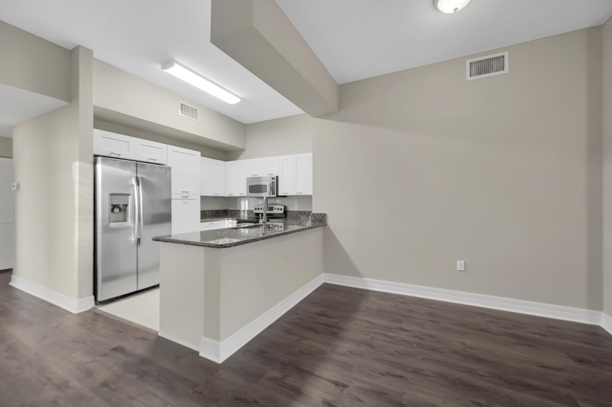 55 Southeast Palermo, Unit 106 Stuart, FL 34994 - Photo 6 of 39 a kitchen with stainless steel appliances granite countertop a refrigerator and a stove top oven