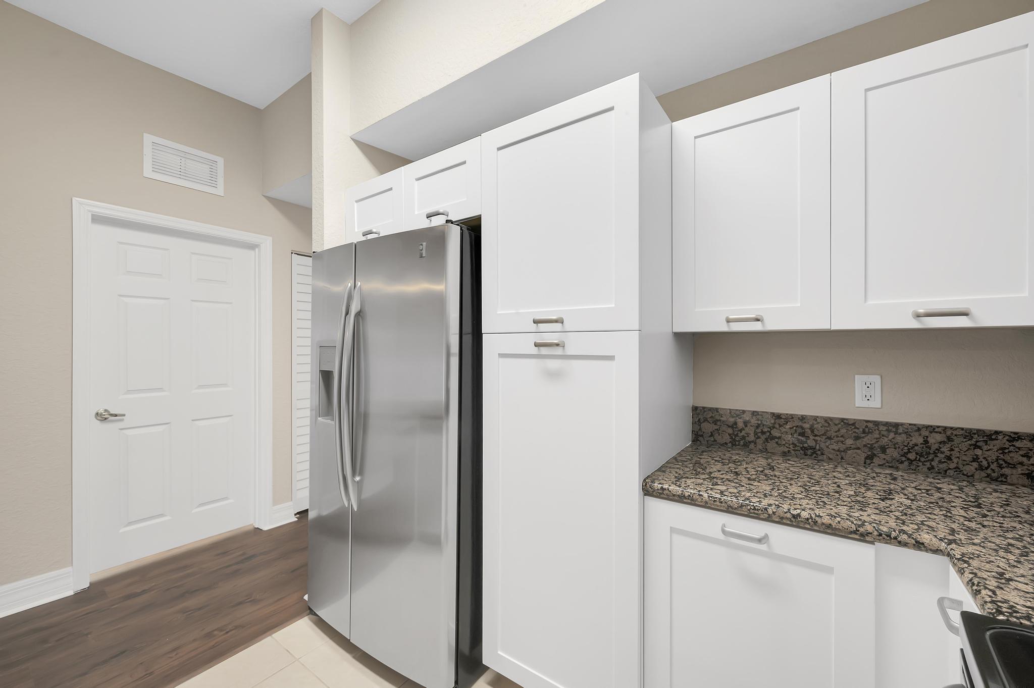 55 Southeast Palermo, Unit 106 Stuart, FL 34994 - Photo 7 of 39 a kitchen with granite countertop white cabinets and refrigerator