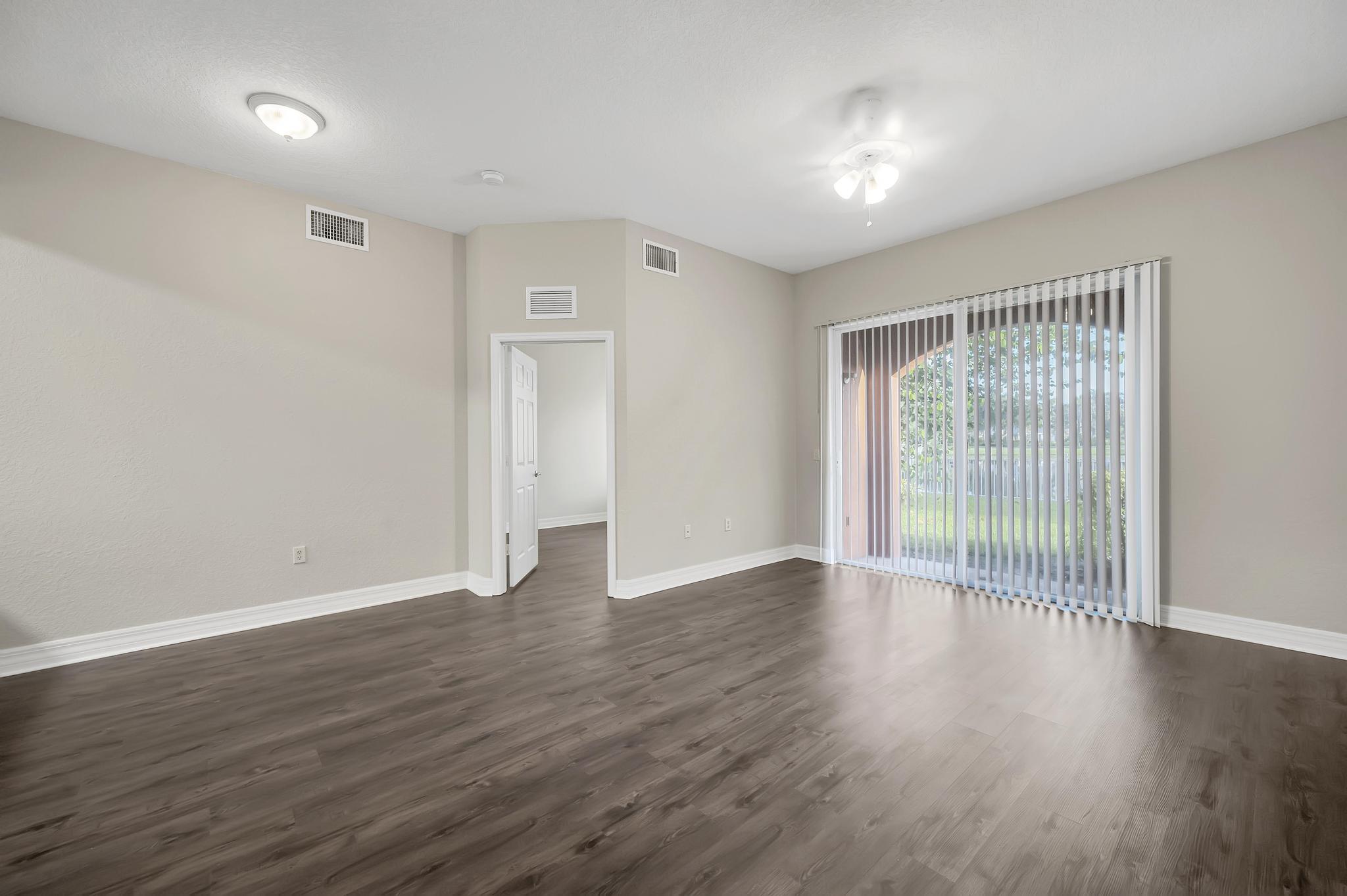 55 Southeast Palermo, Unit 106 Stuart, FL 34994 - Photo 8 of 39 a view of an empty room with wooden floor and a window