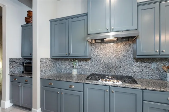 a kitchen with stainless steel appliances granite countertop a sink stove and cabinets