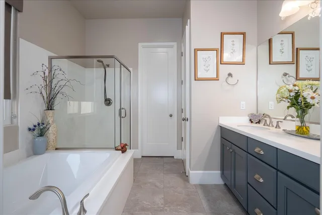 a spacious bathroom with a tub sink and mirror