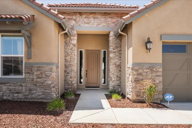 a front view of a house with a garden