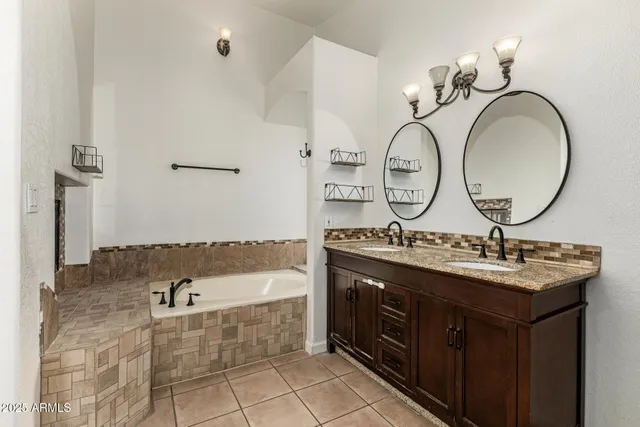 a bathroom with a double vanity sink mirror and bathtub