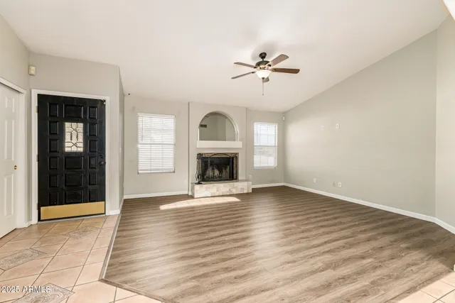 a view of empty room with wooden floor and fireplace