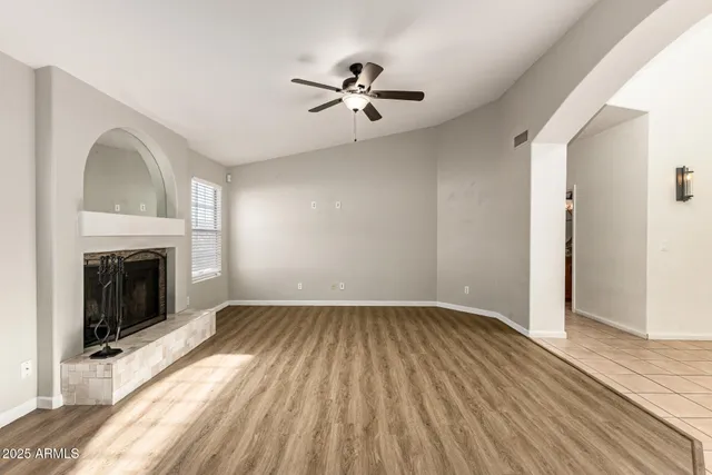 a view of empty room with wooden floor and fireplace