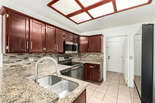 a kitchen with stainless steel appliances granite countertop a sink stove and refrigerator