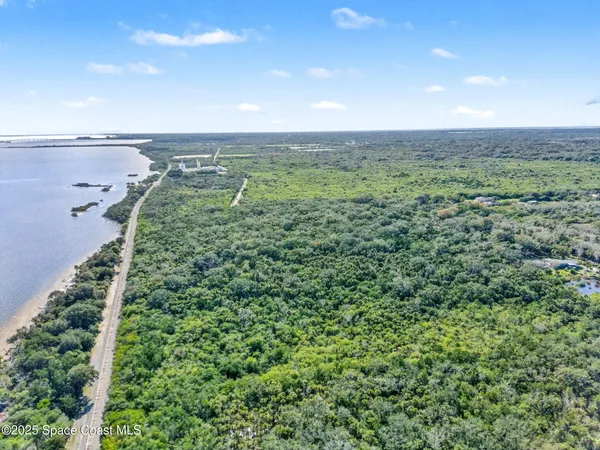 an aerial view of residential houses with outdoor space and trees