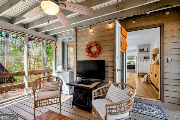 a living room with furniture a flat screen tv and a floor to ceiling window
